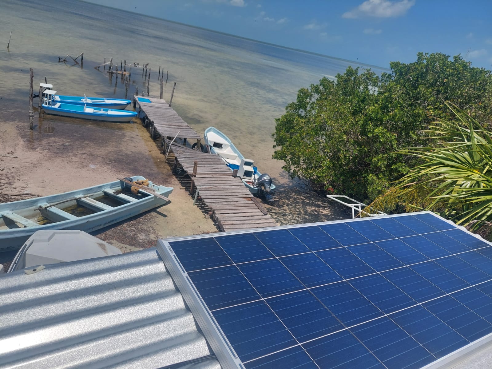 A solar panel on a dock above some fishing boats