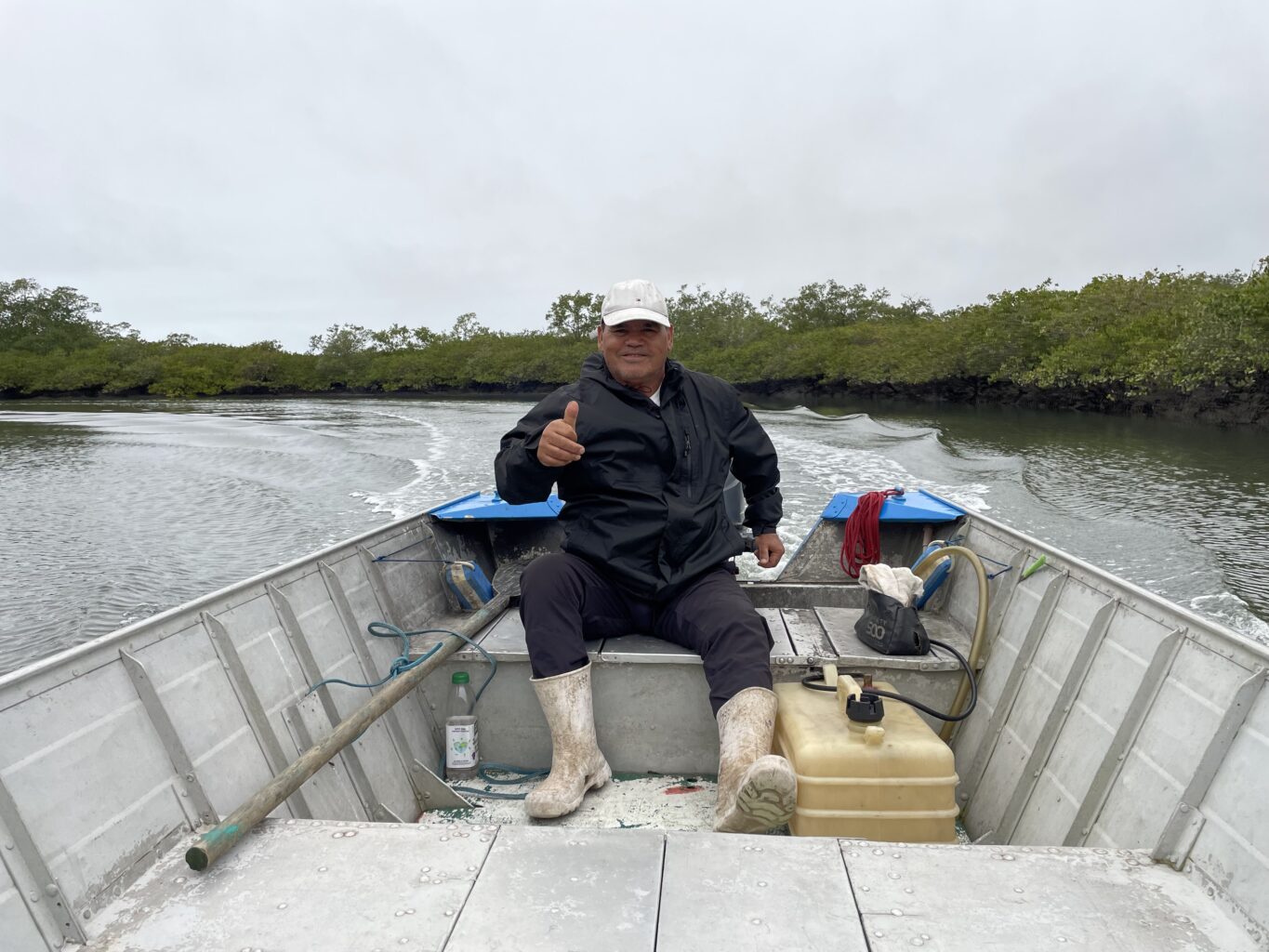 A man in a small boat gives a thumbs up