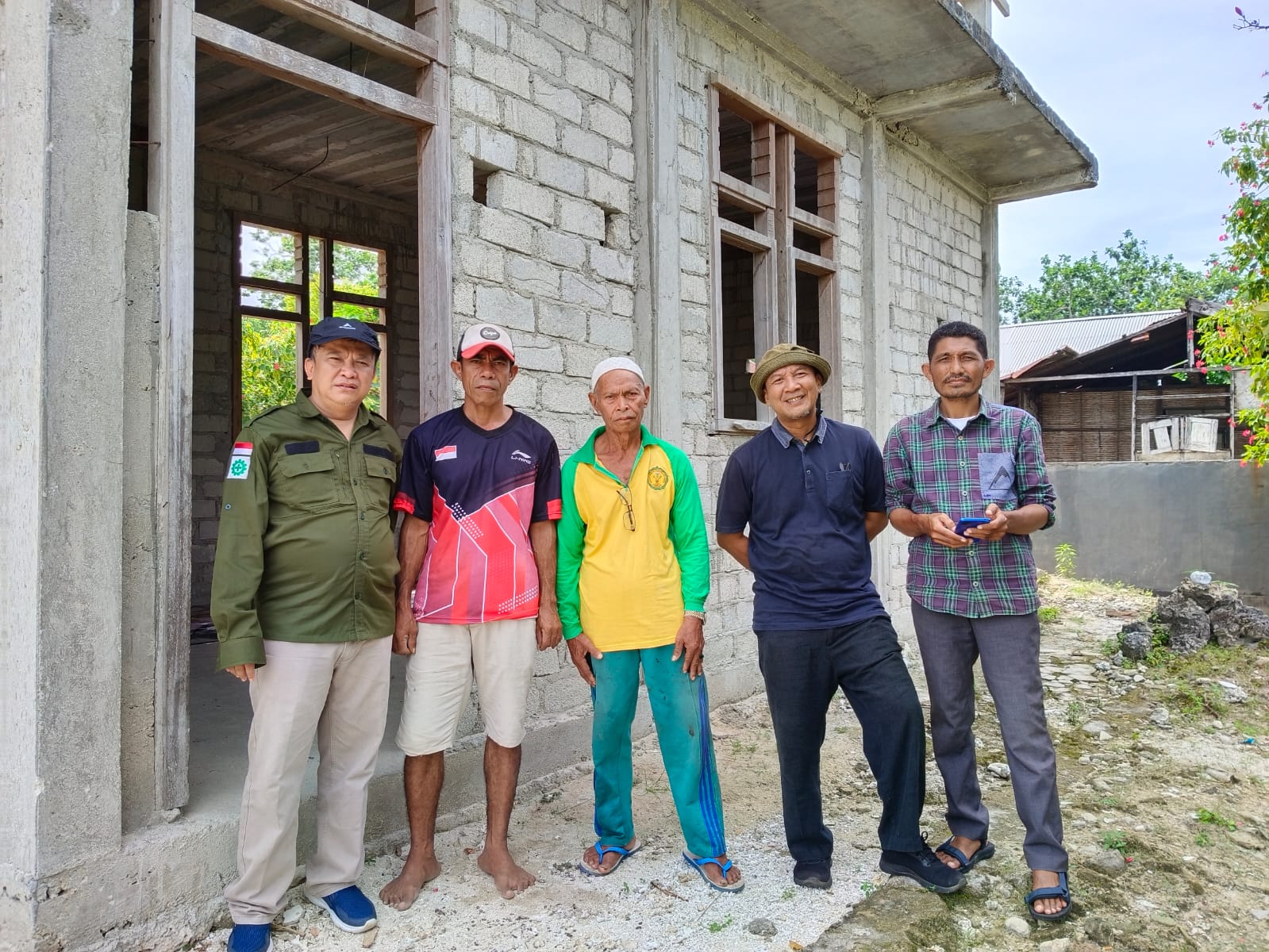 5 men standing in front of a newly constructed building
