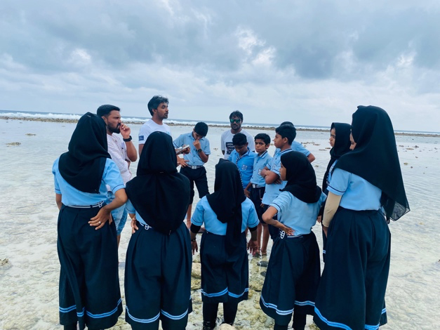 A group of students listens to an instructor