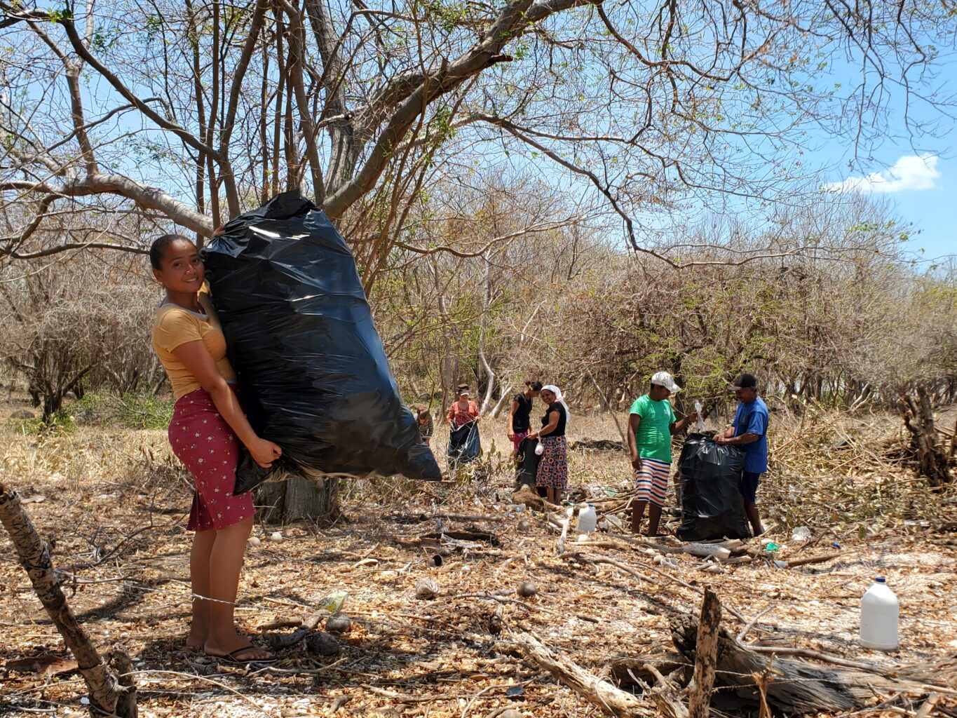 People with full garbage bags on beach