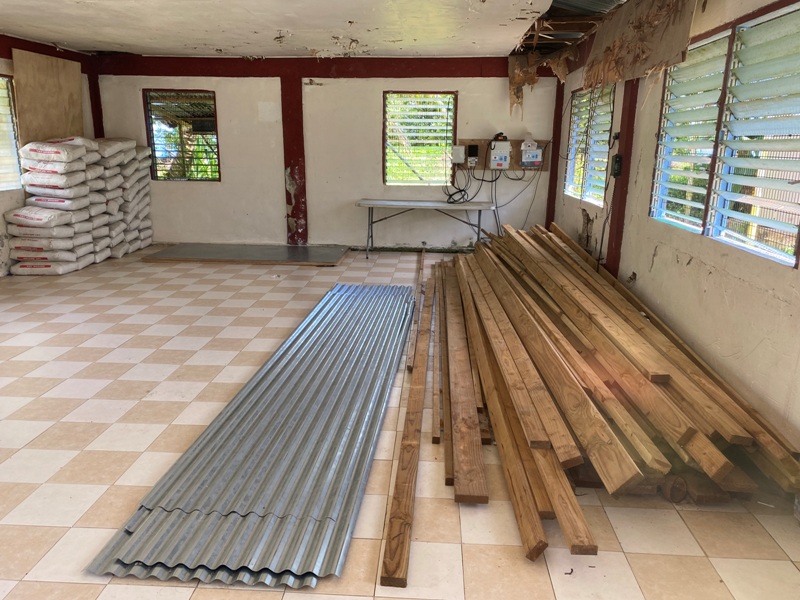 Long wooden boards and sheets of metal stored in a dilapidated building