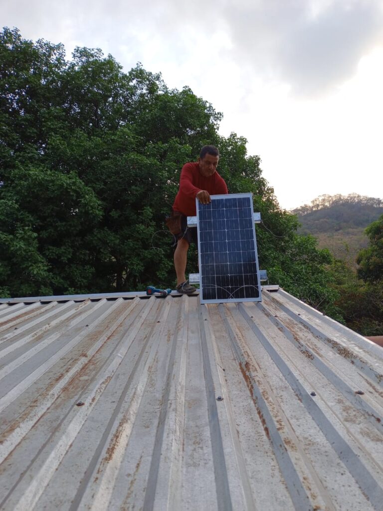 Man installs solar panel on roof