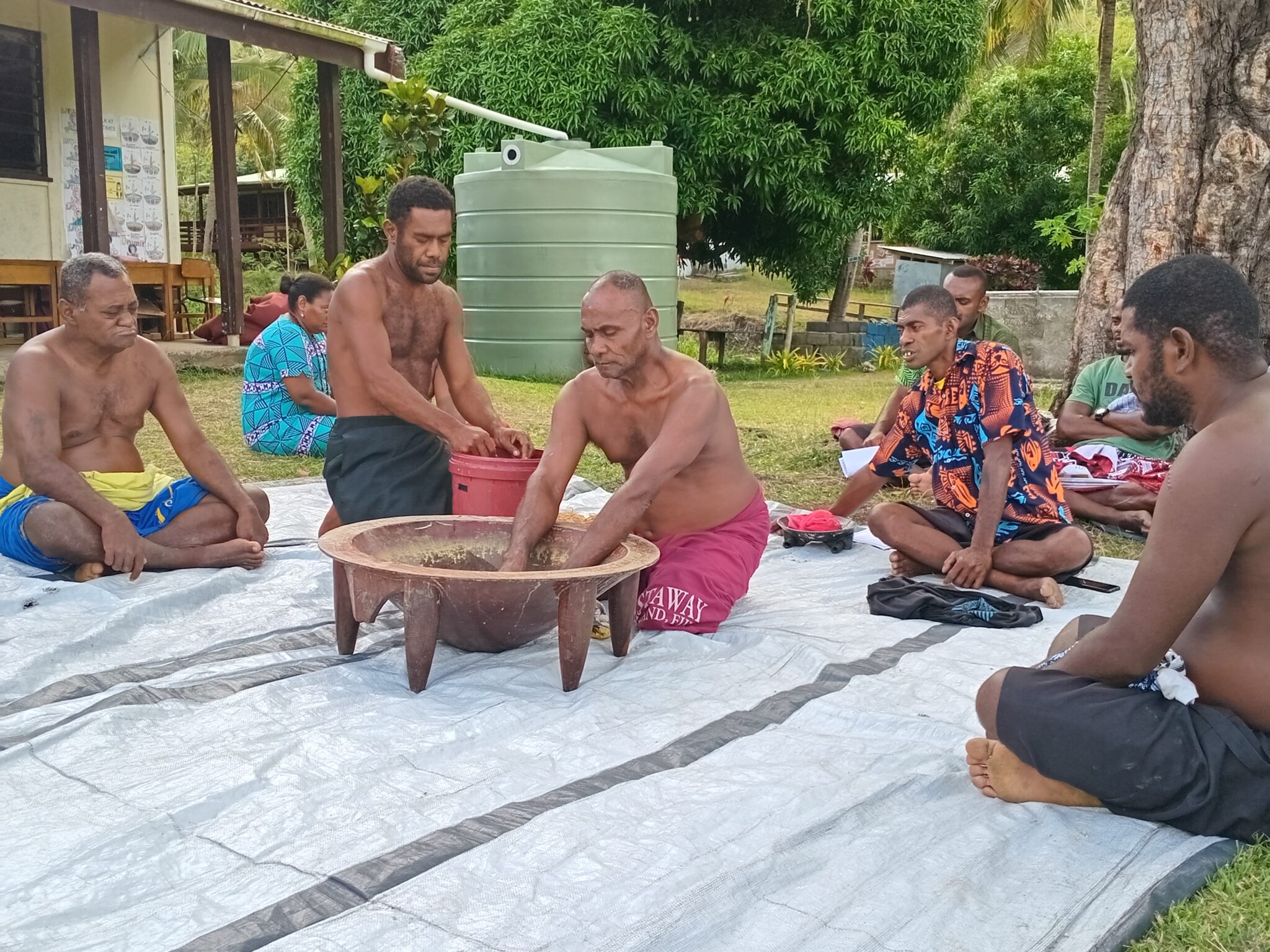 A group of people performs a kava ceremony