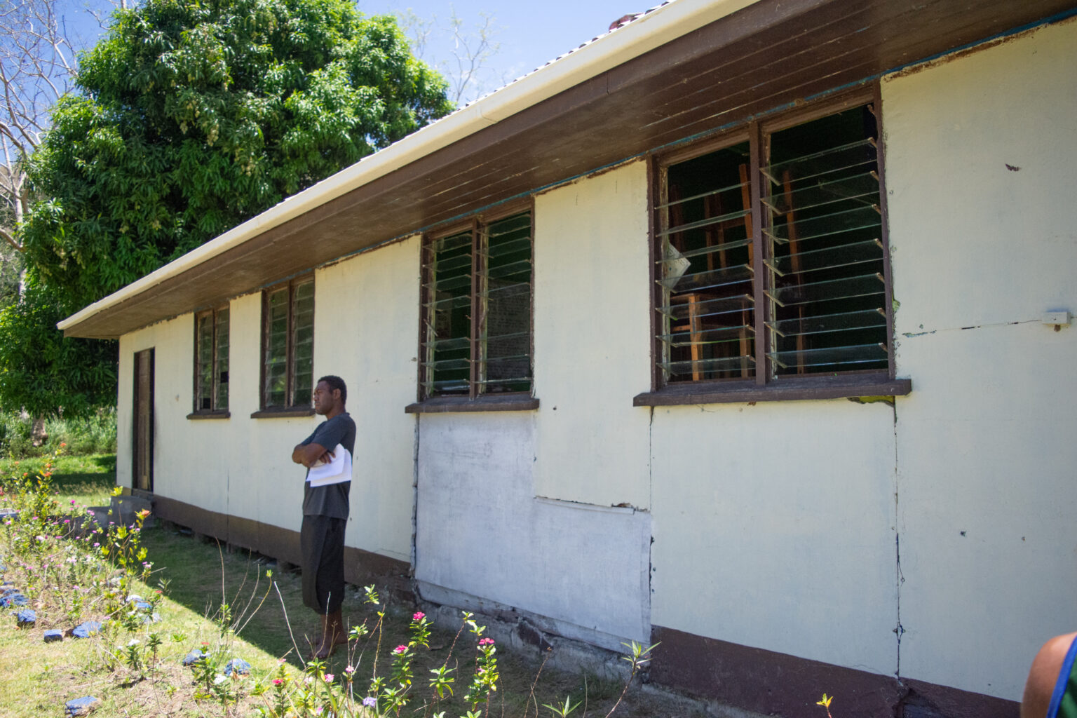 Man stands outside dilapidated building