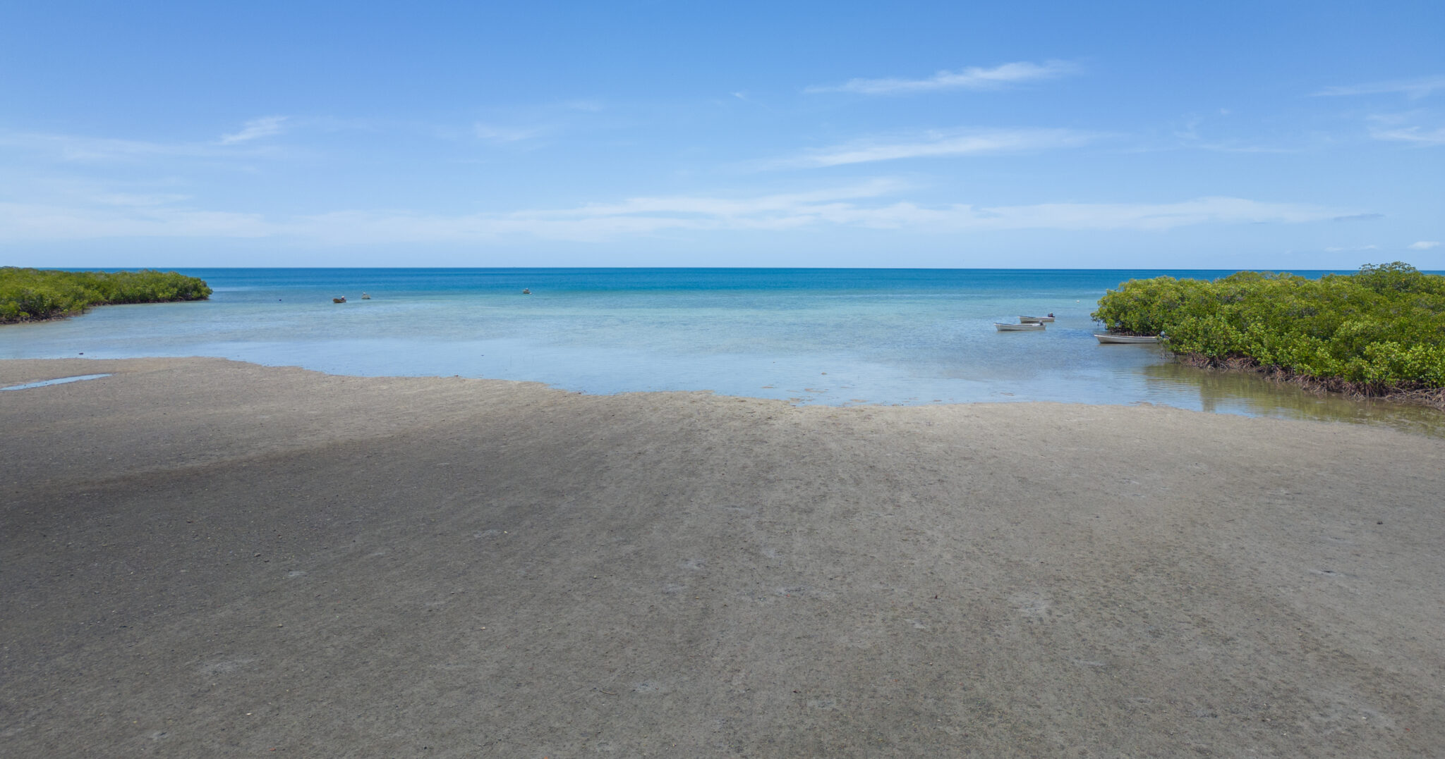 A long beach leads to blue water